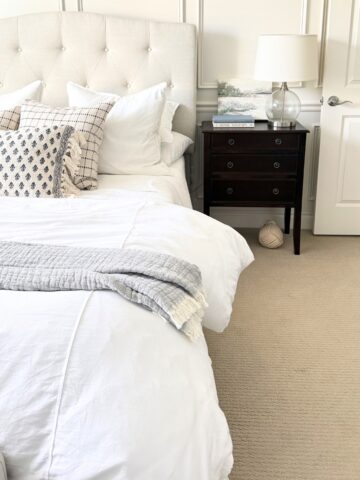 upholstered bed next to dark wood nightstand