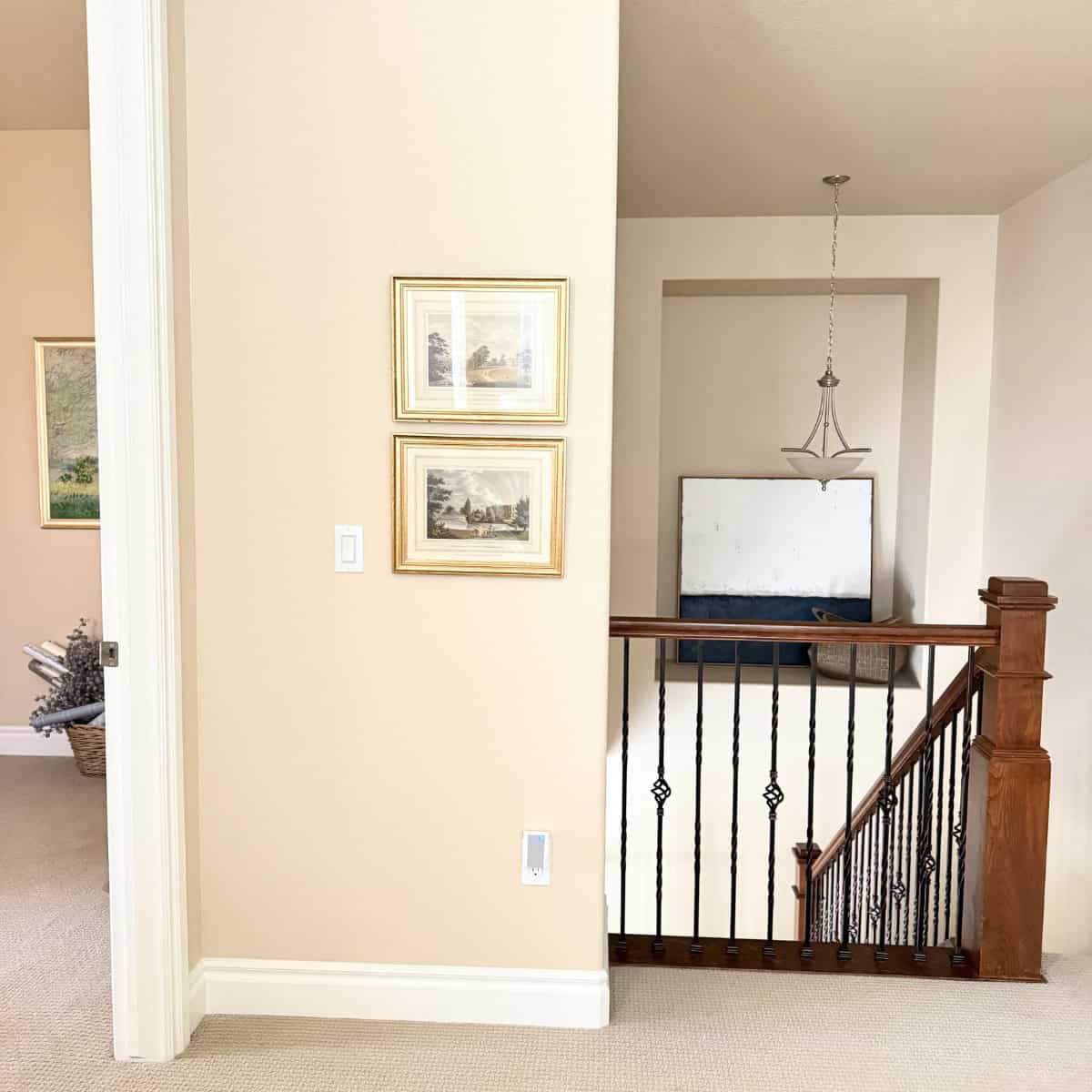two vintage art prints hanging in a hallway