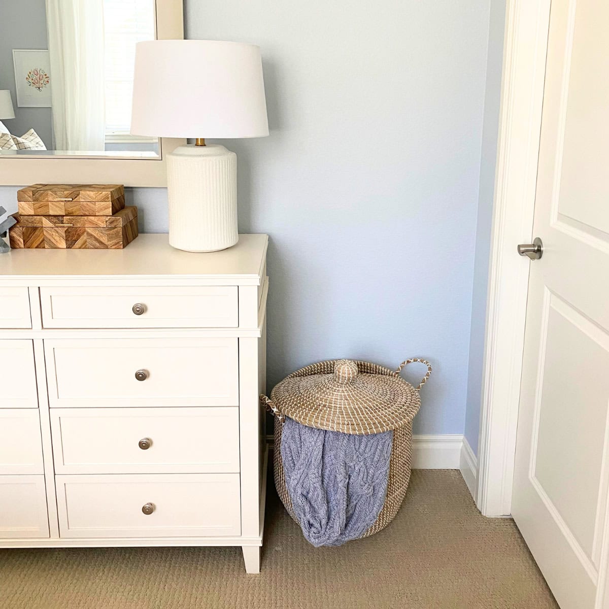 basket with lid next to a white dresser