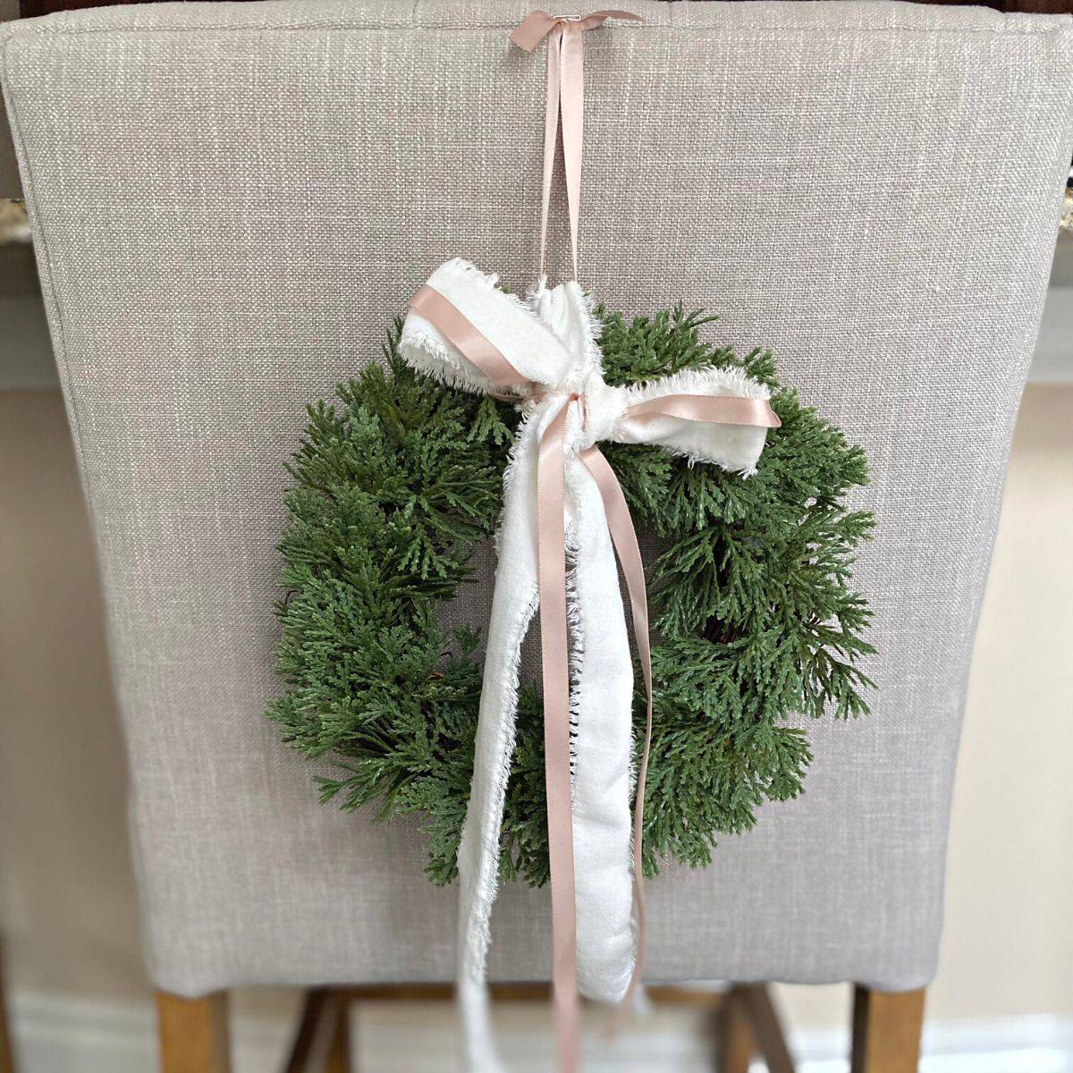 Faux cedar holiday wreath on back of chair