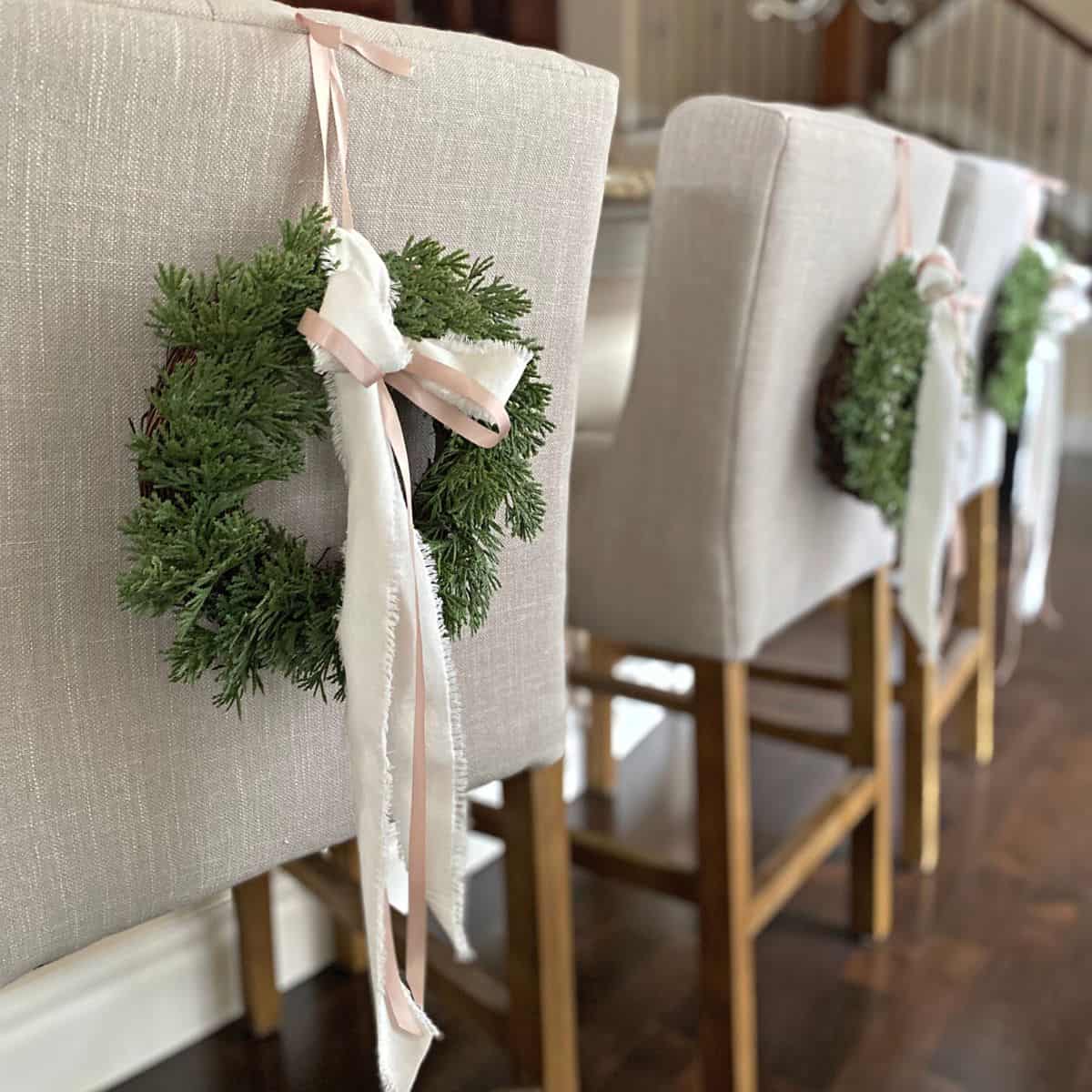 Faux cedar holiday wreaths on back of chair