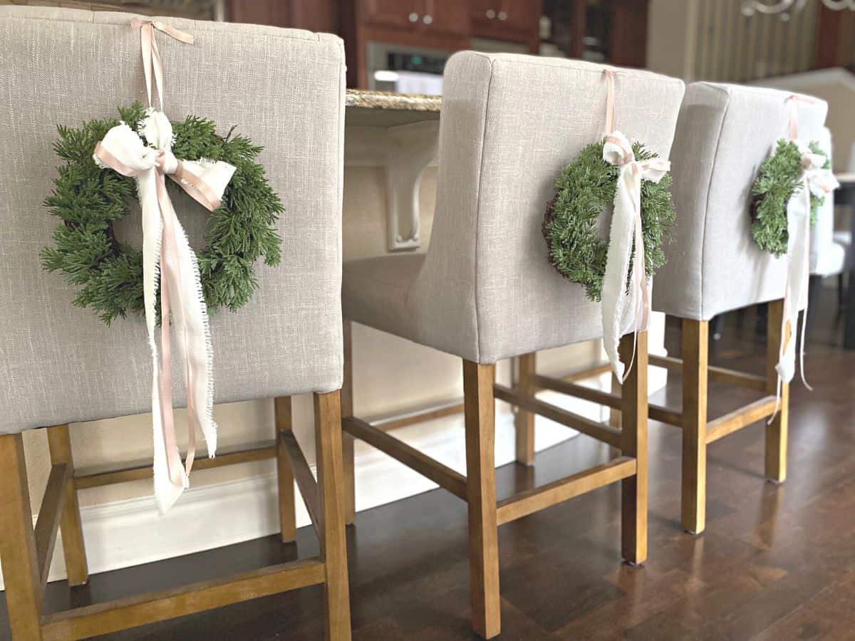 three pretty holiday wreaths on chairs