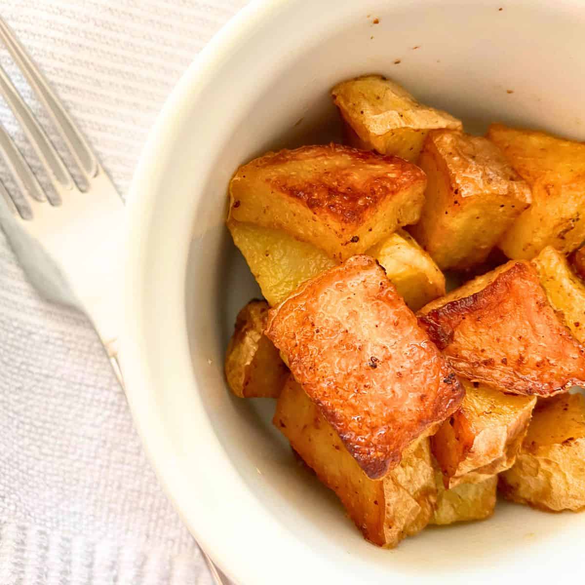 Home fries in a white Apilco ramekin atop a Turkish towel