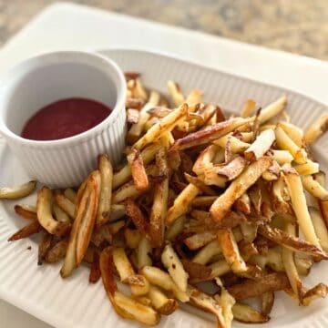 Baked French fries on a platter with ketchup