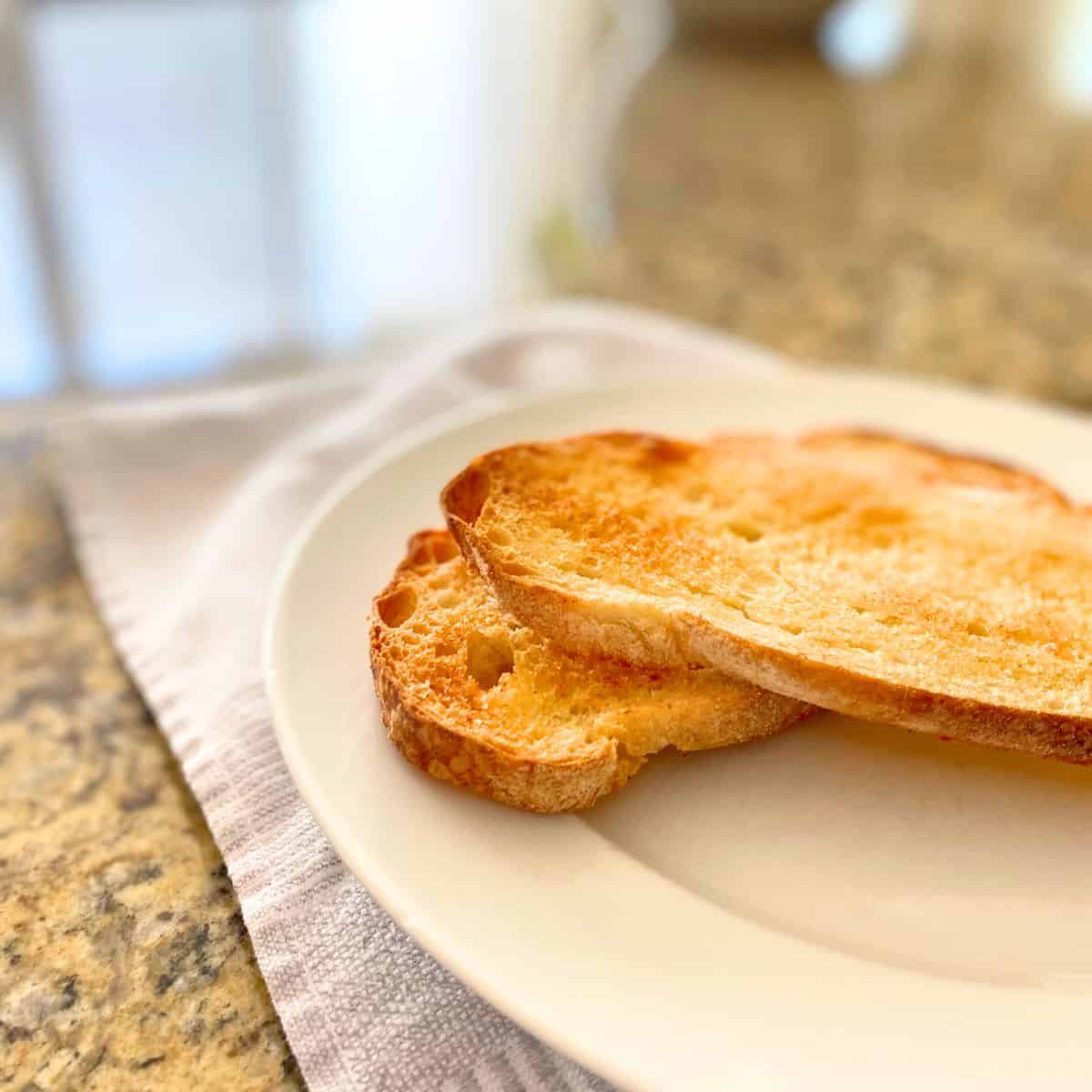 Homemade garlic bread roasted in the oven on a white dinner plate