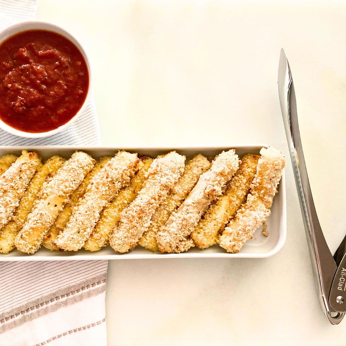 baked homemade cheese sticks with sauce