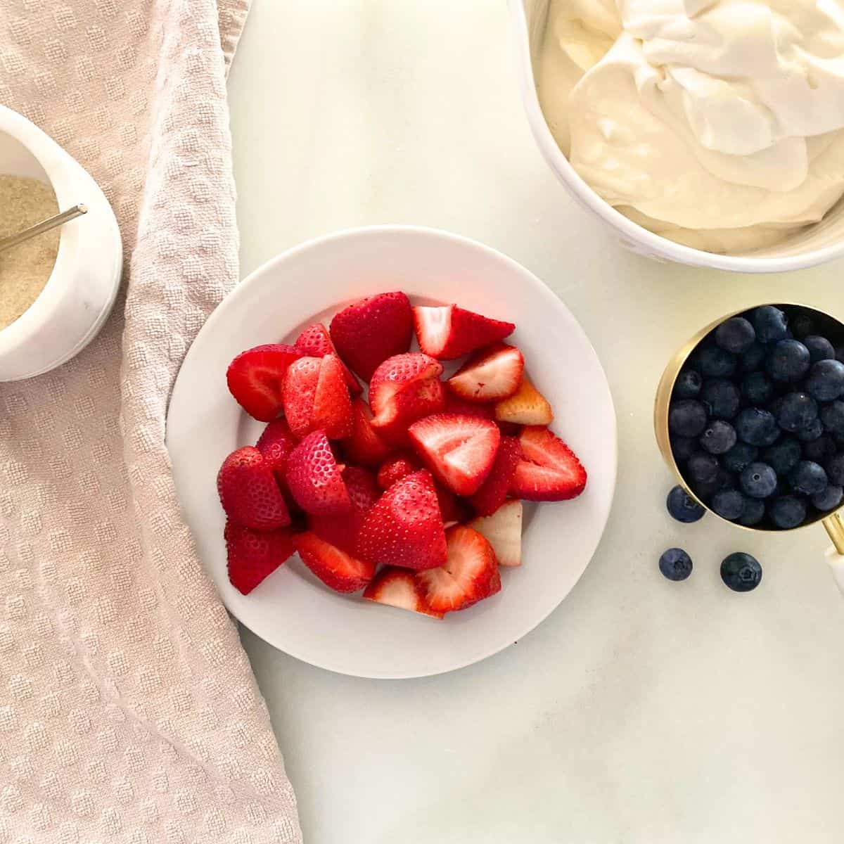 ingredients for berries and cream, including strawberries and blueberries