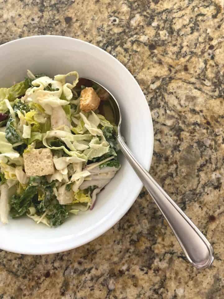 Kale Caesar salad in a small white cereal bowl
