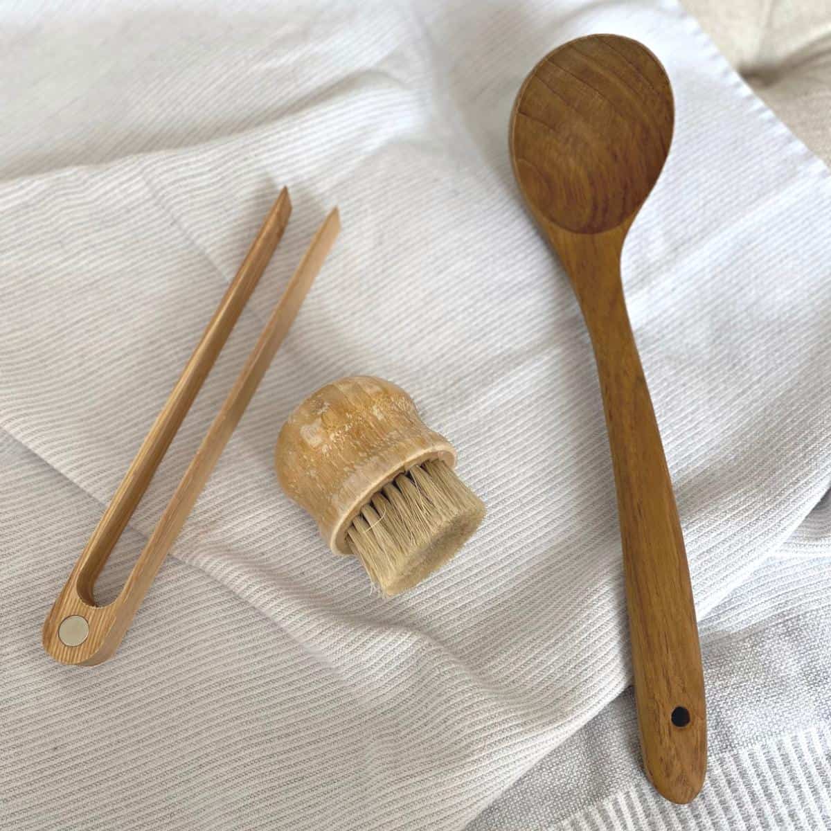 Wood kitchen utensils, including toast tongs, vegetable brush and wood ladle