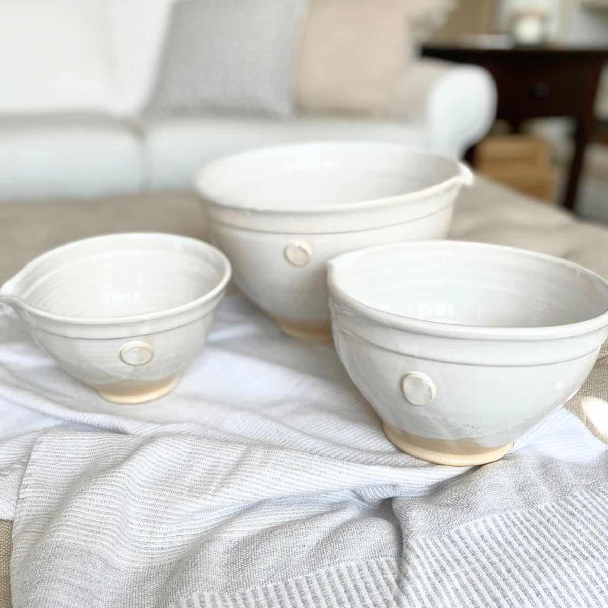 Set of three handthrown pottery mixing bowls on a neutral cotton towel