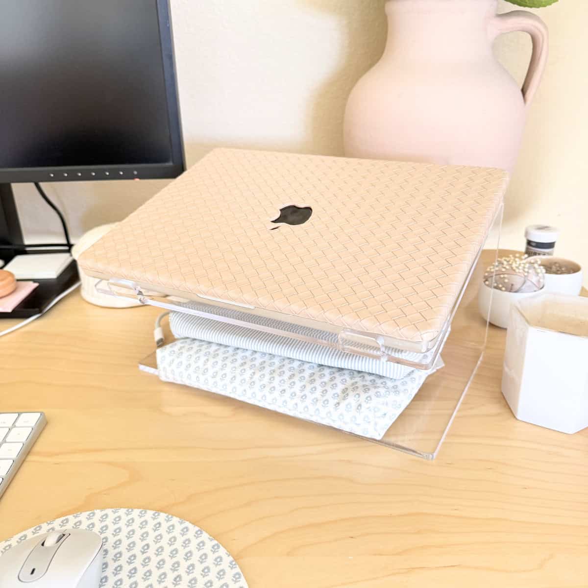 laptop on acrylic stand atop desk