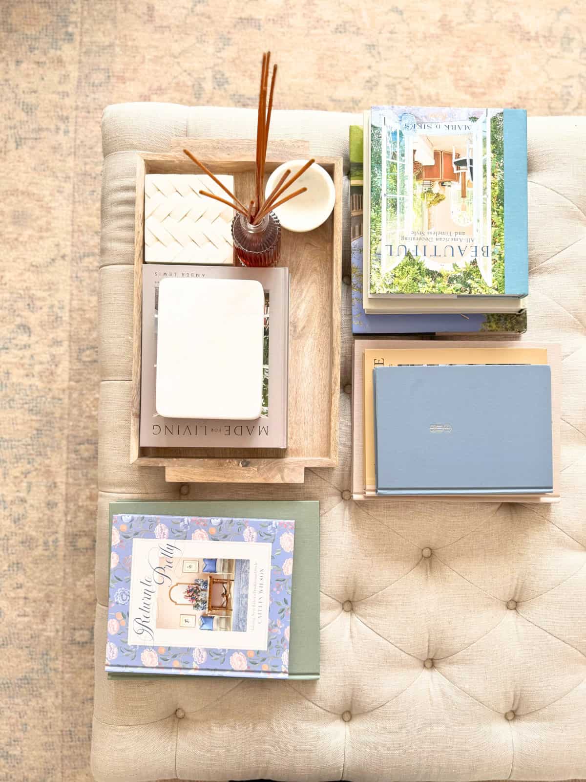 tufted ottoman styled with books and boxes