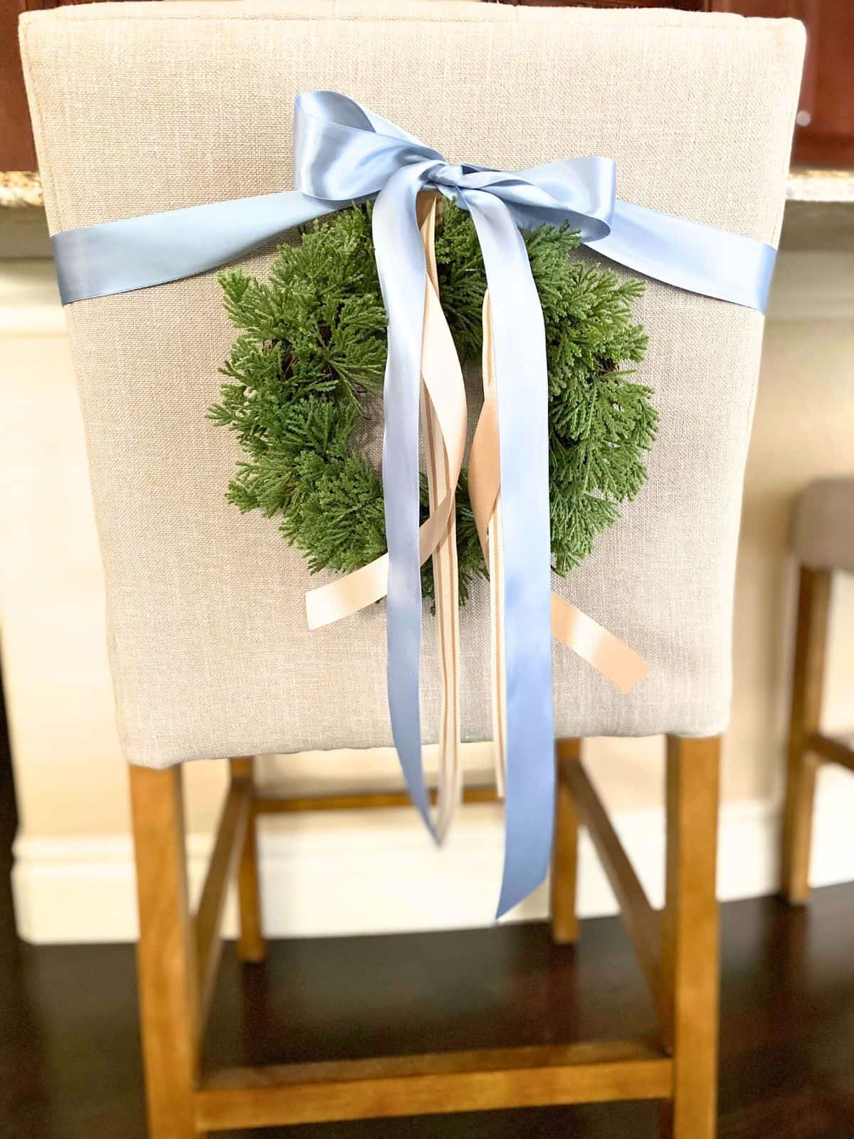 mini wreath with ribbon on back of counter stool