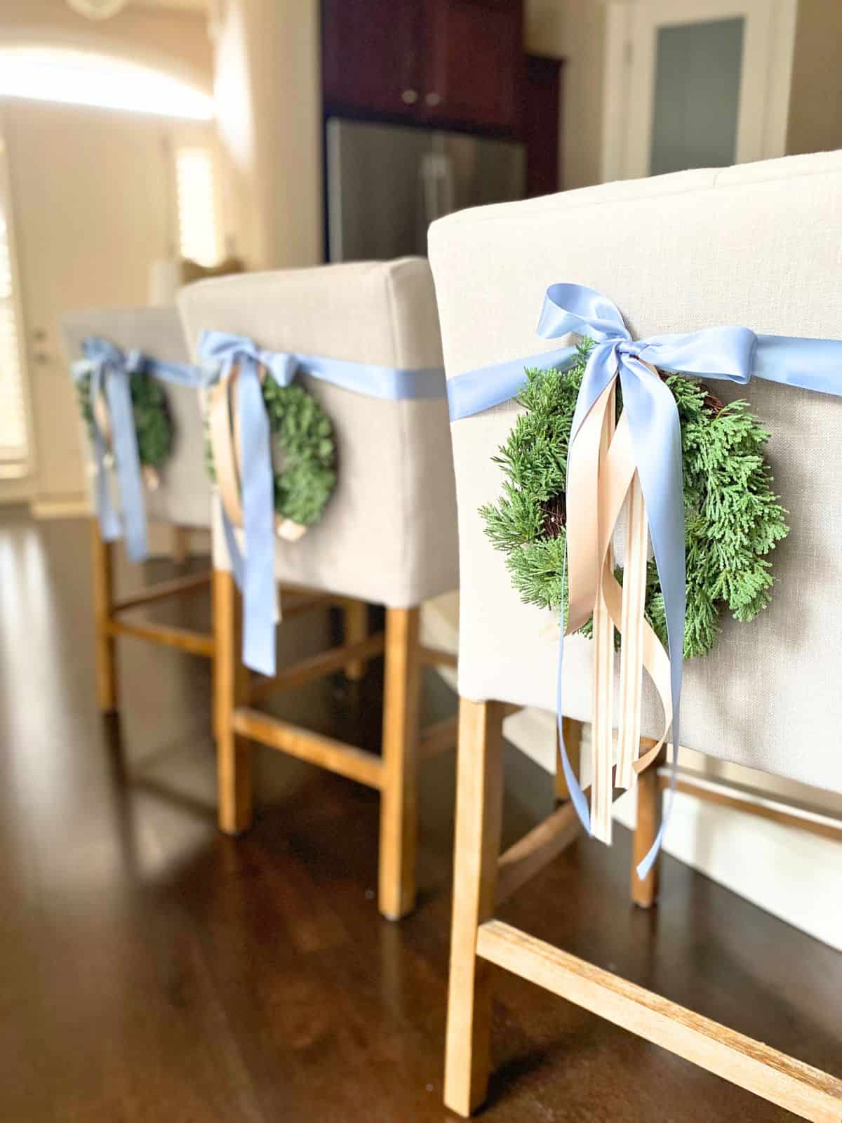 mini wreaths with ribbon on back of counter stools