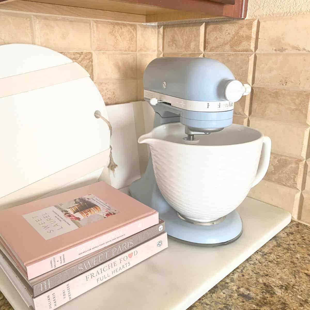 misty blue kitchenaid stand mixer with cookbooks