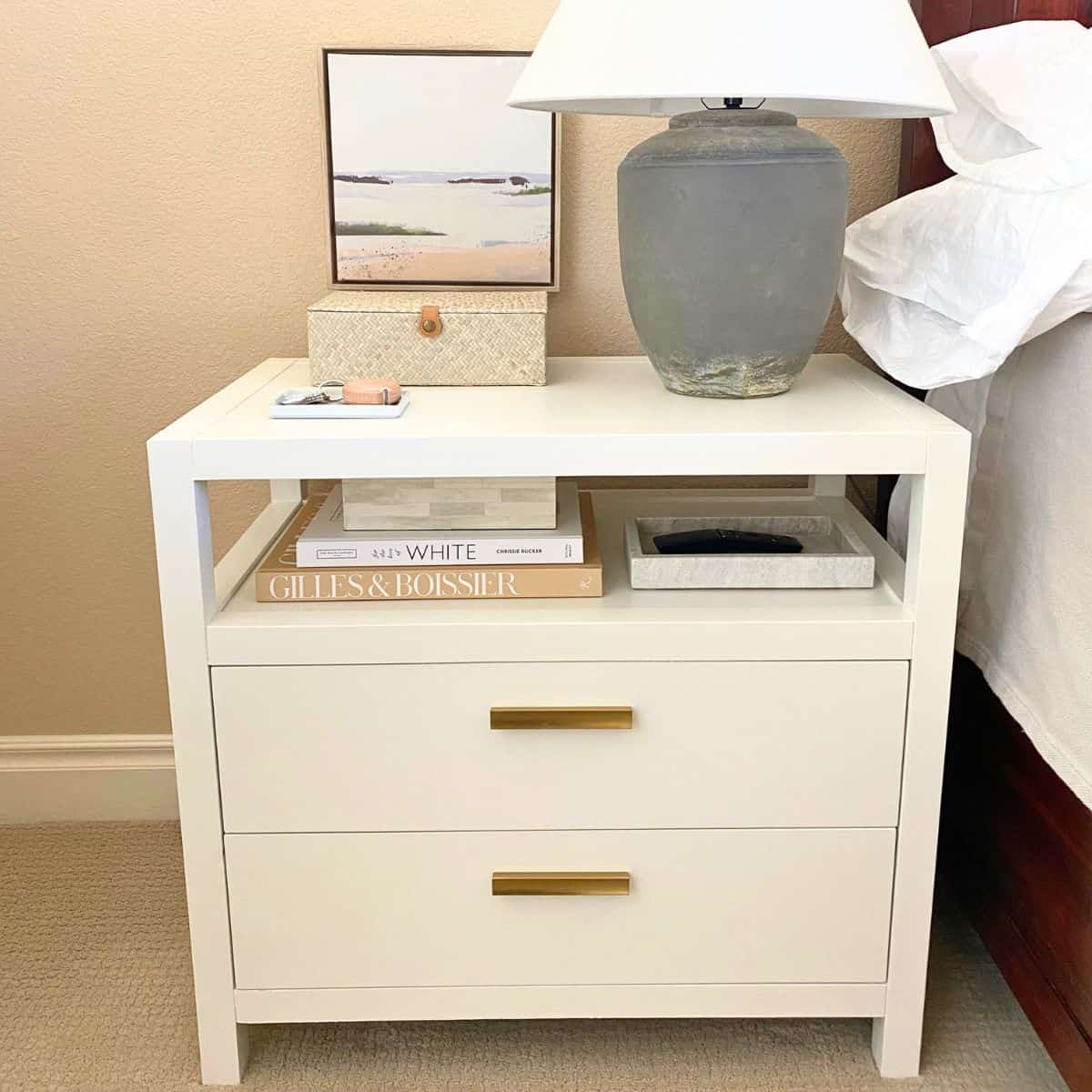 stacked books and boxes on a bedside table