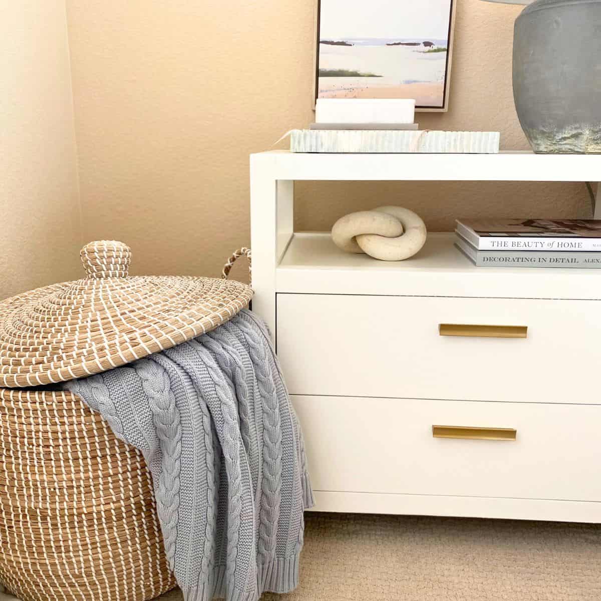 tall basket beside a white nightstand