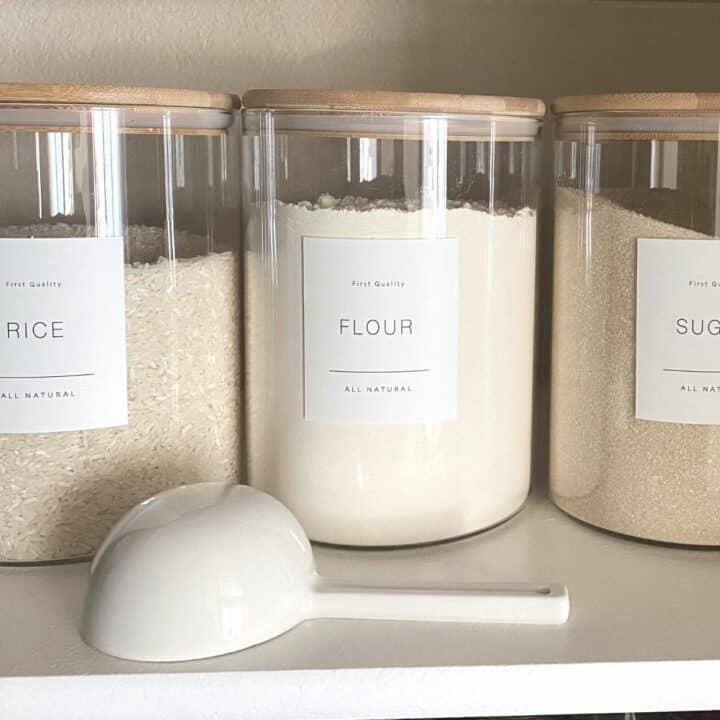 glass pantry jars with wood lids, storing rice, flour and sugar. A ceramic scoop sits in front.