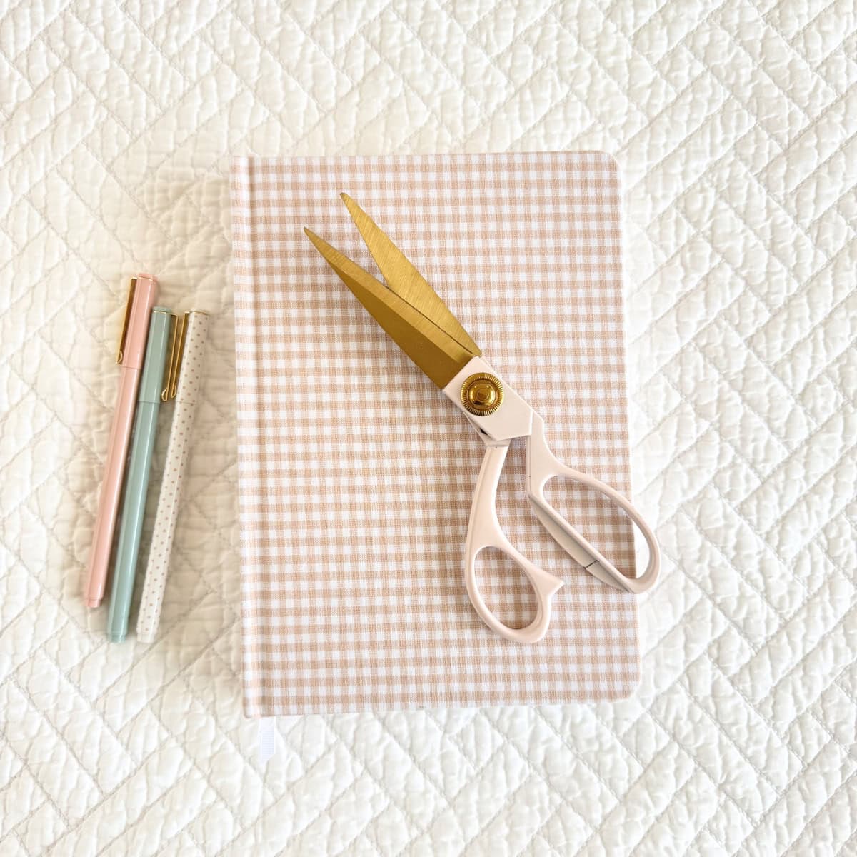 pale pink scissors on top of pink gingham journal