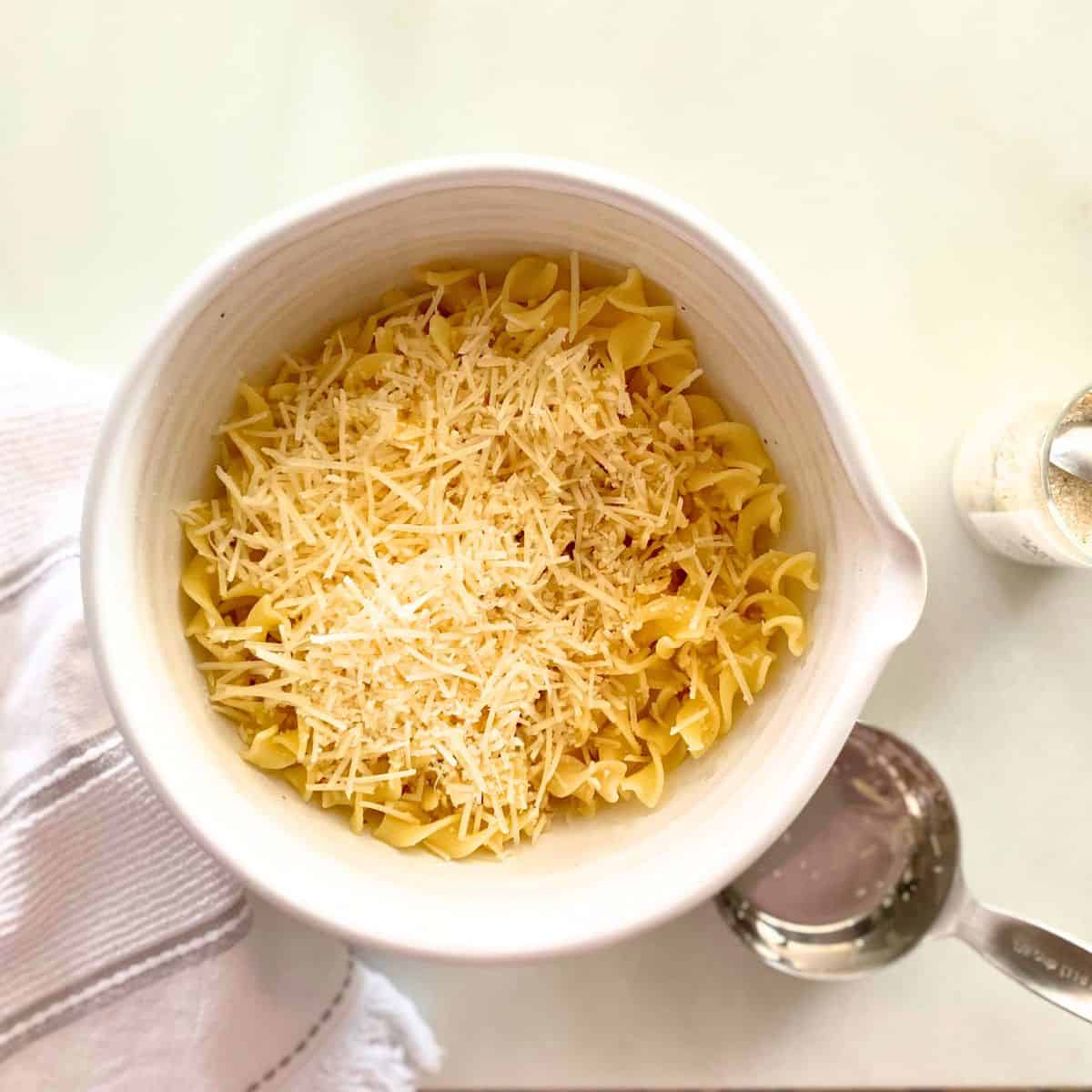 Parmesan atop garlic buttered noodles