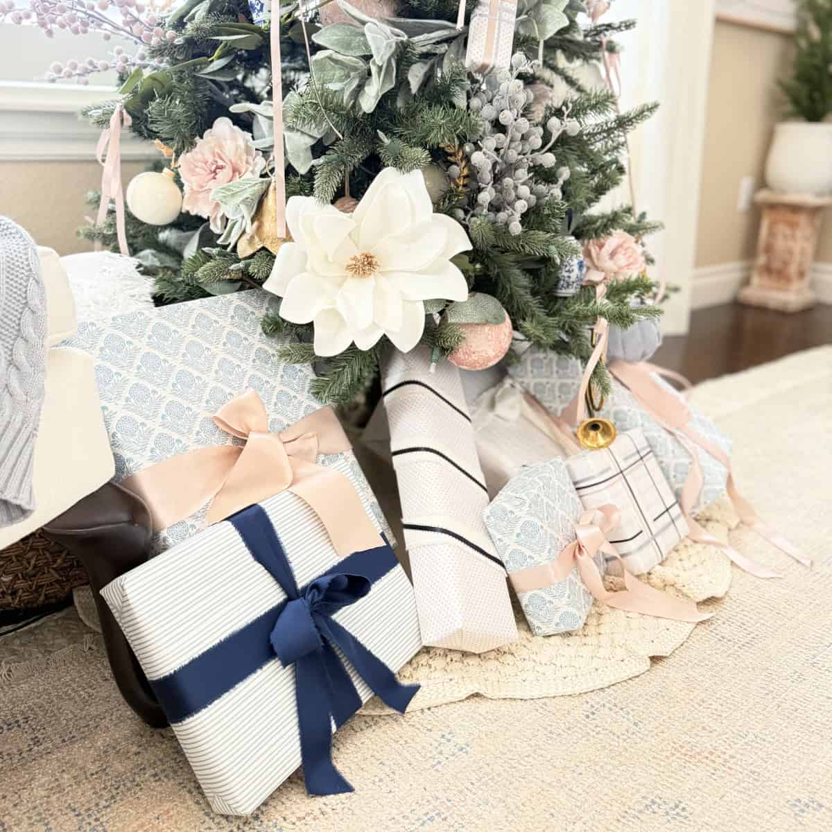 blue and pink wrapped presents under christmas tree