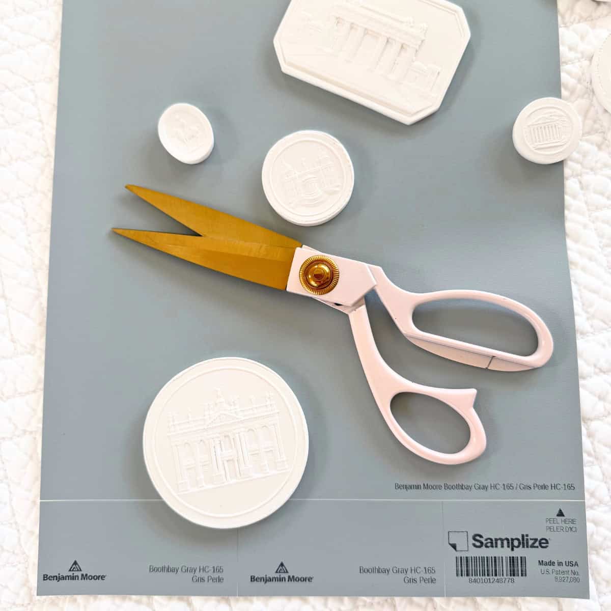 scissors and intaglios on blue paint sample sheet
