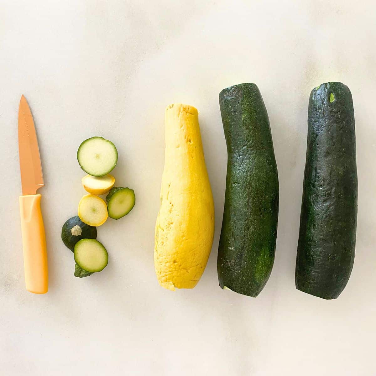 tops and bottoms cut off of yellow squash and zucchini