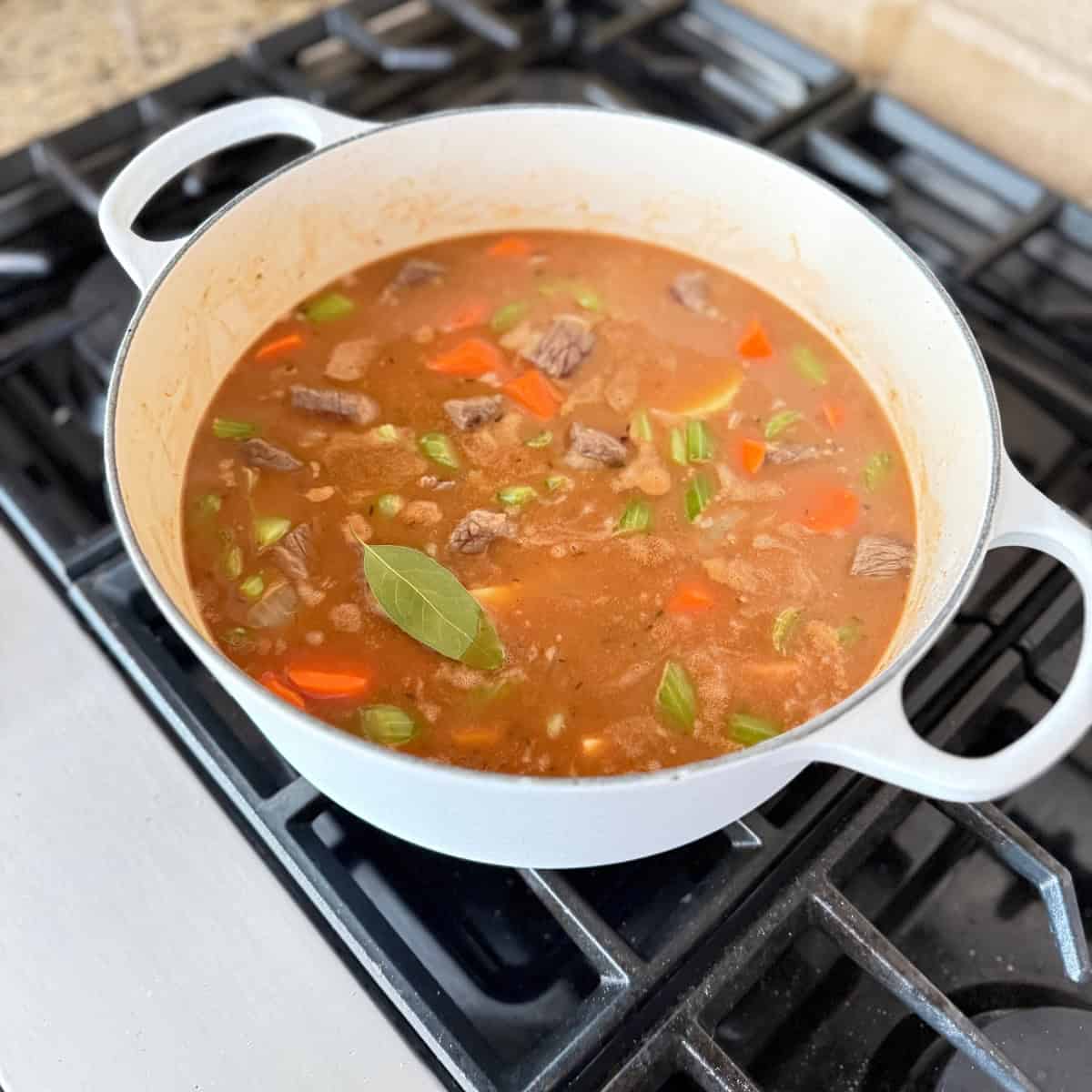 adding bay leaf to cooking stew