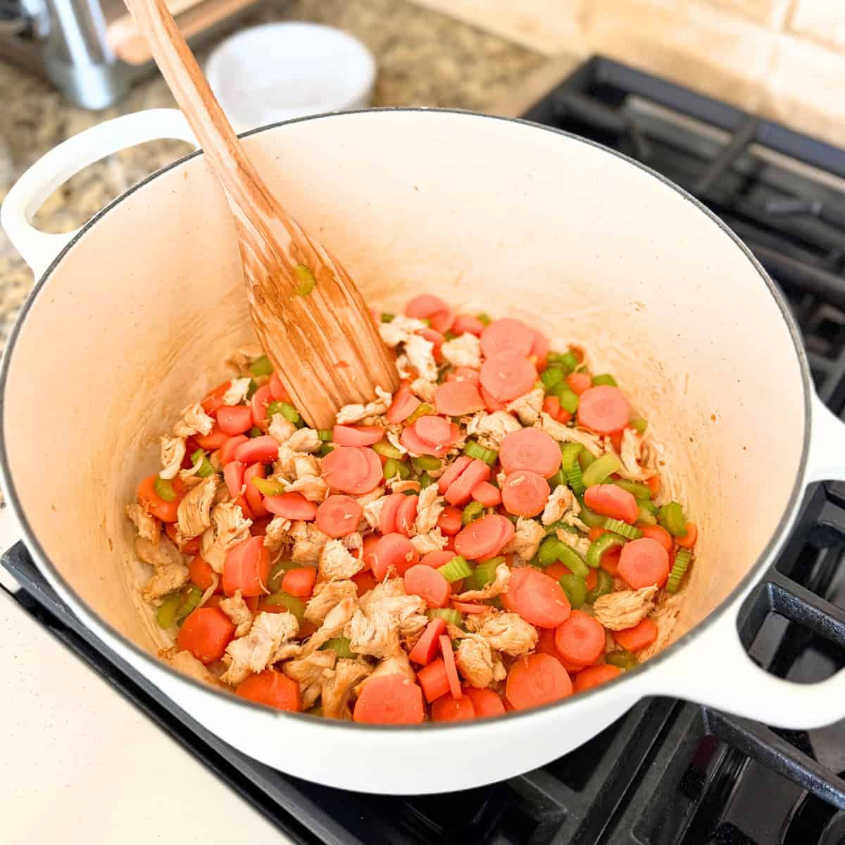 carrots and celery added to pot of chicken noodle soup