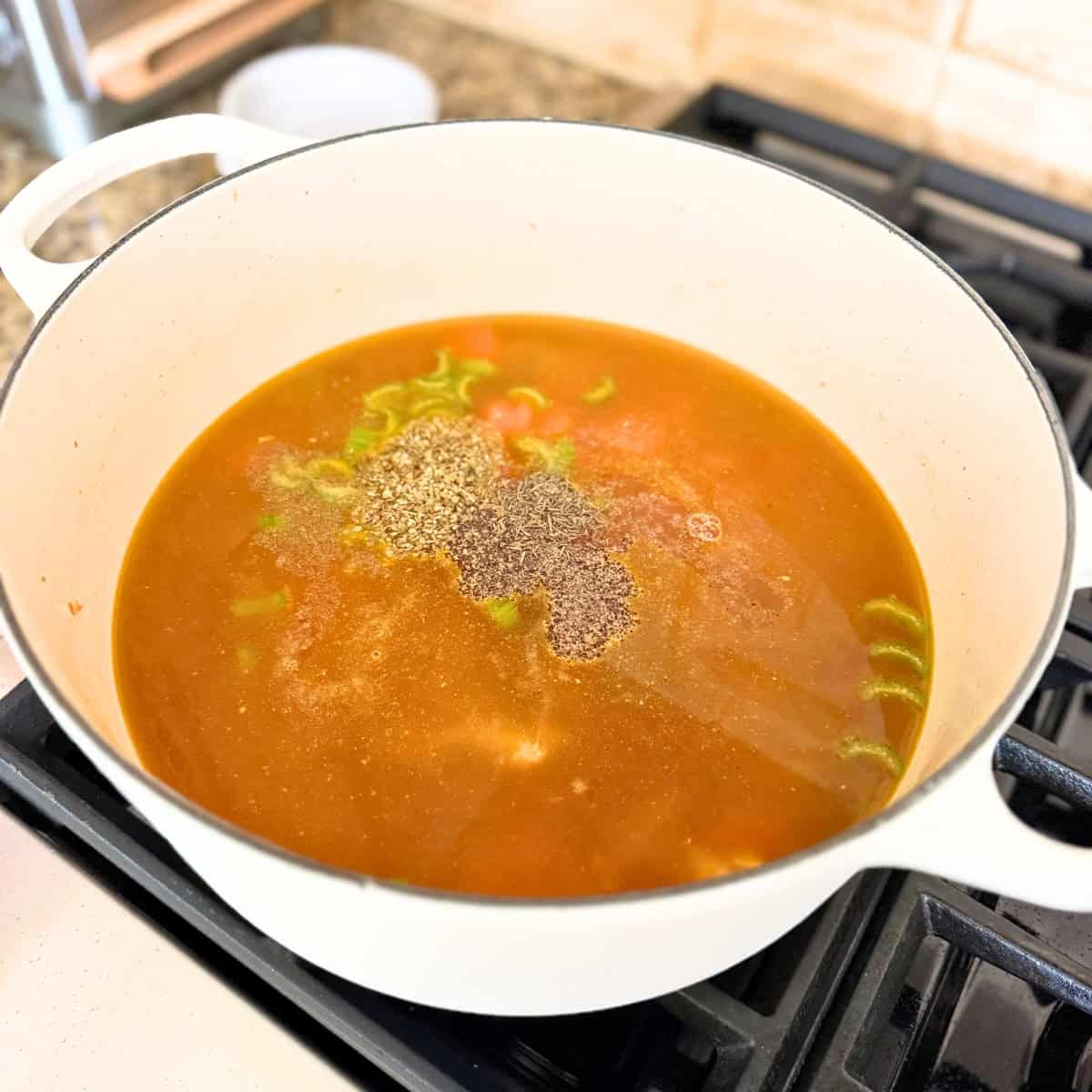 seasonings added to pot of chicken noodle soup