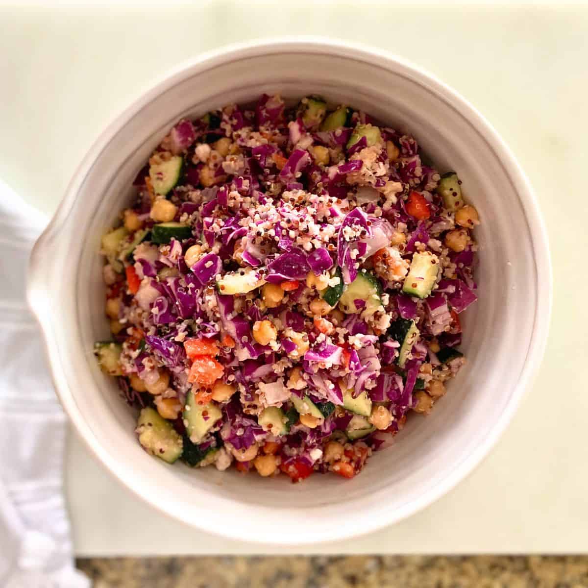 Quinoa salad mixed together in a hand thrown mixing bowl