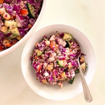Individual portion of quinoa salad in a bowl next to a hand thrown mixing bowl from above