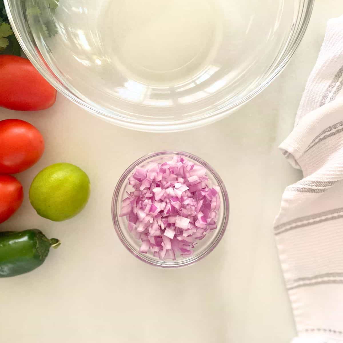 finely diced red onion in glass mixing bowl