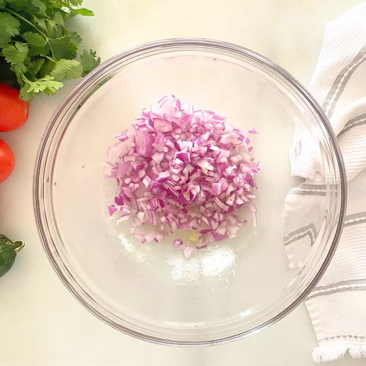 lime over red onion in a glass mixing bowl