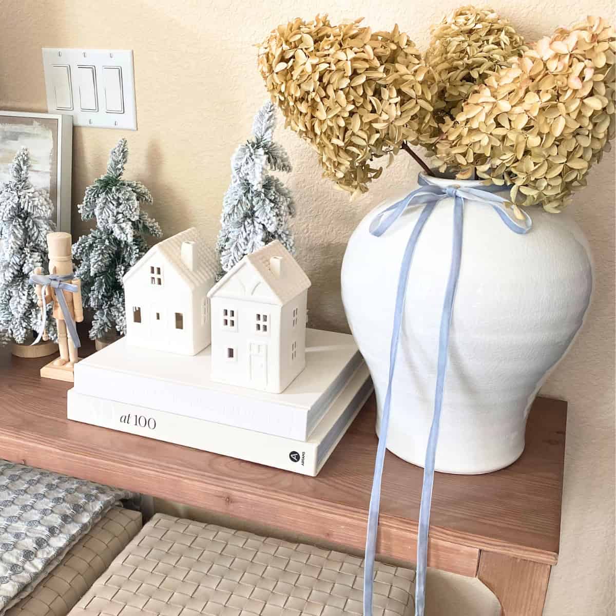 console table decorated for coastal christmas theme with blue ribbon on white vase