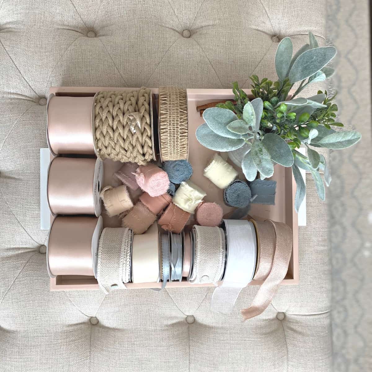 Ribbon rolls stored on a pink lacquered tray