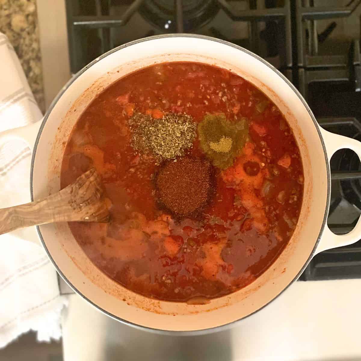 Added seasonings to chili on stove