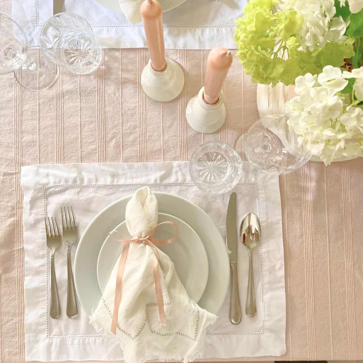 napkin with pink ribbon napkin ring on white porcelain dinnerware