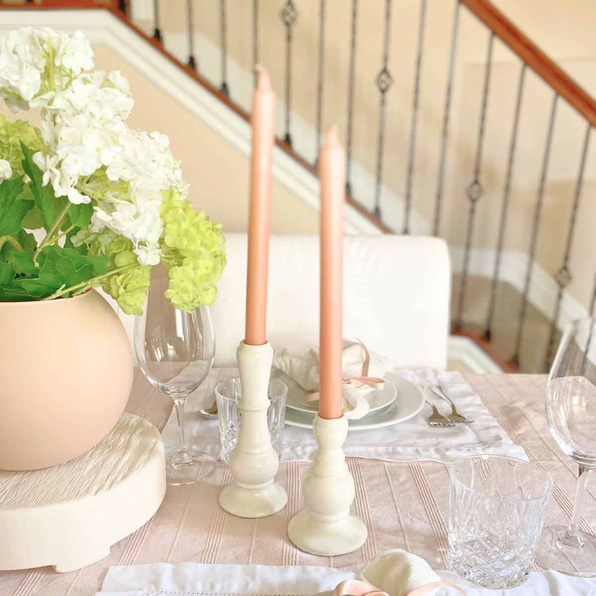 blush pink taper candles in white ceramic holders