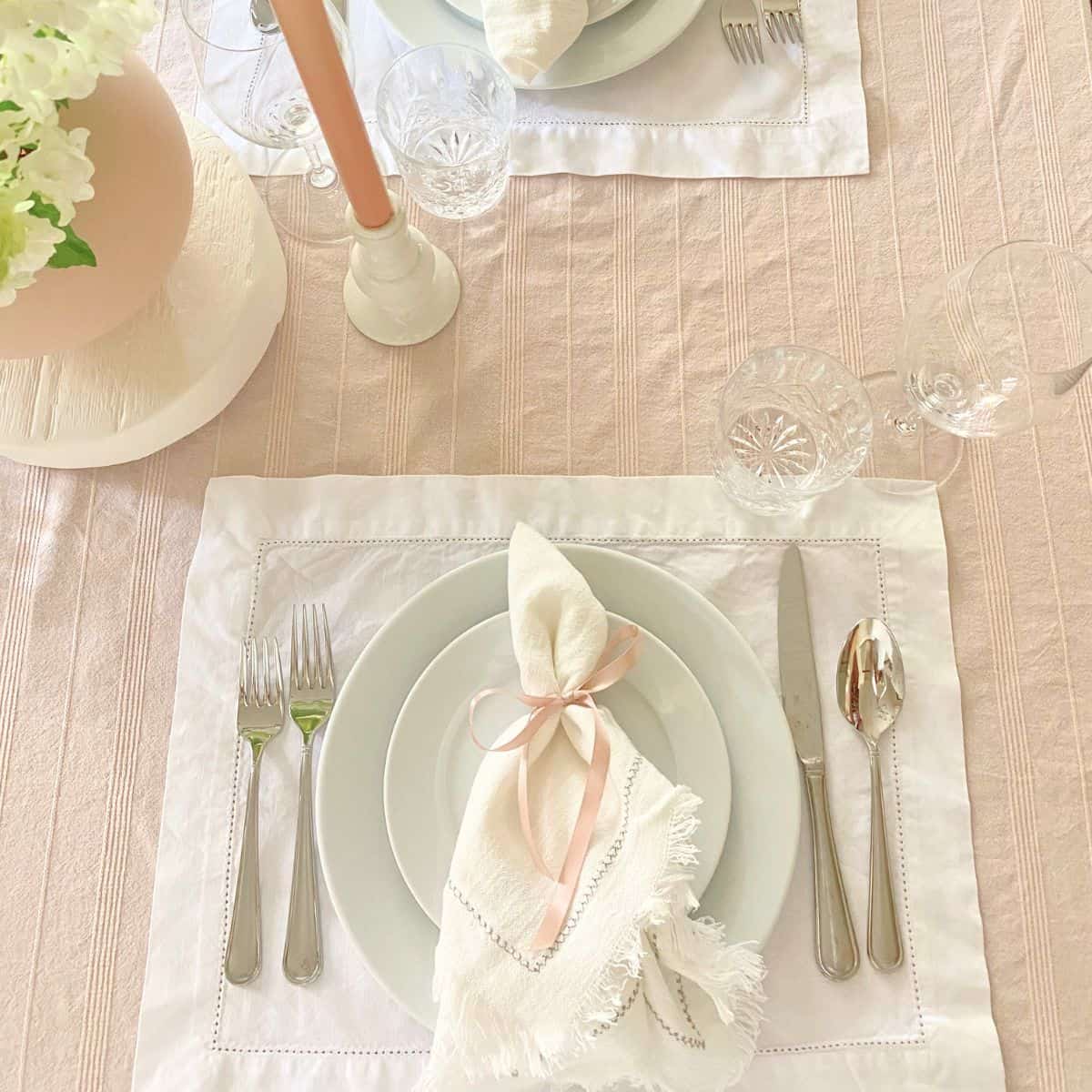 napkin with pink ribbon napkin ring on white porcelain dinnerware