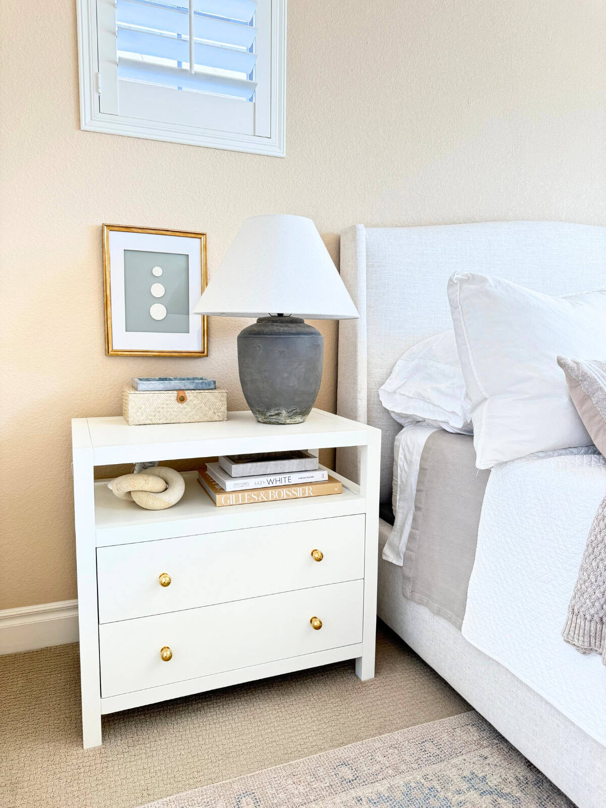 framed intaglio wall art displayed behind nightstand