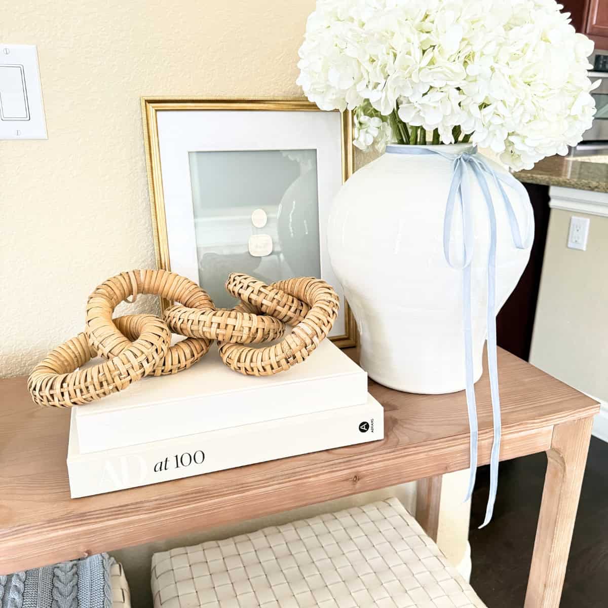 console table decorated with a vase and books and art