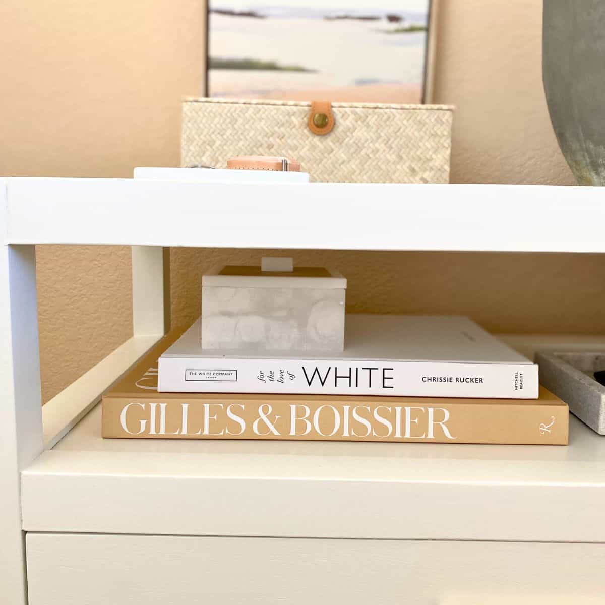 stacked books and boxes on a bedside table