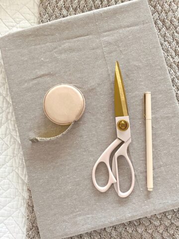 Linen fabric covered book with tape measure, scissors and pen