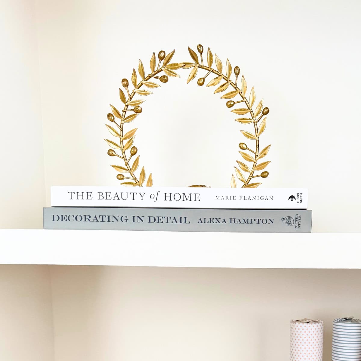 brass laurel decor sits atop books