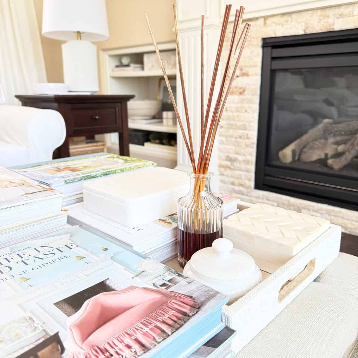 tray styled on an ottoman with diffuser and marble boxes and books
