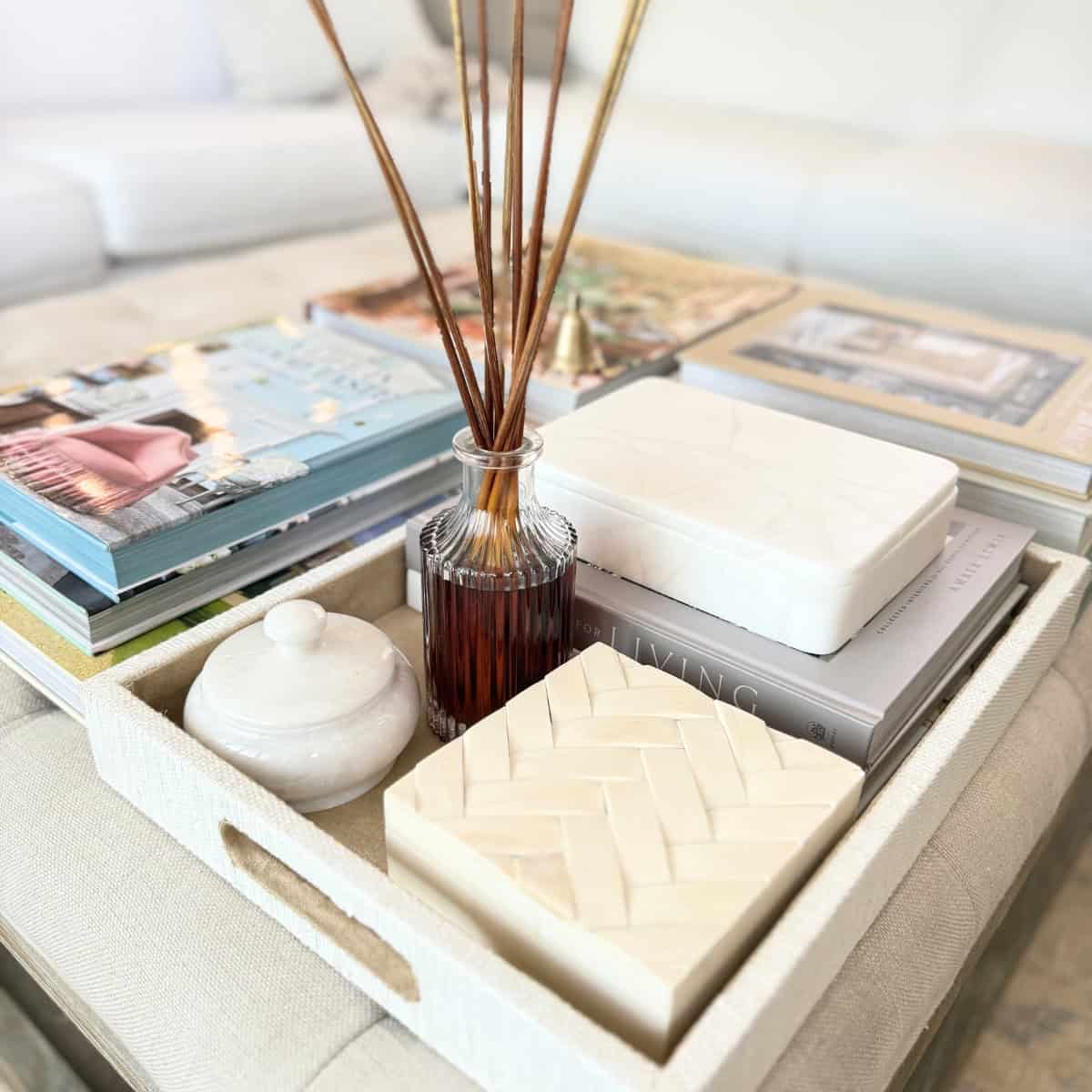 books and tray with decor styled on a tufted ottoman