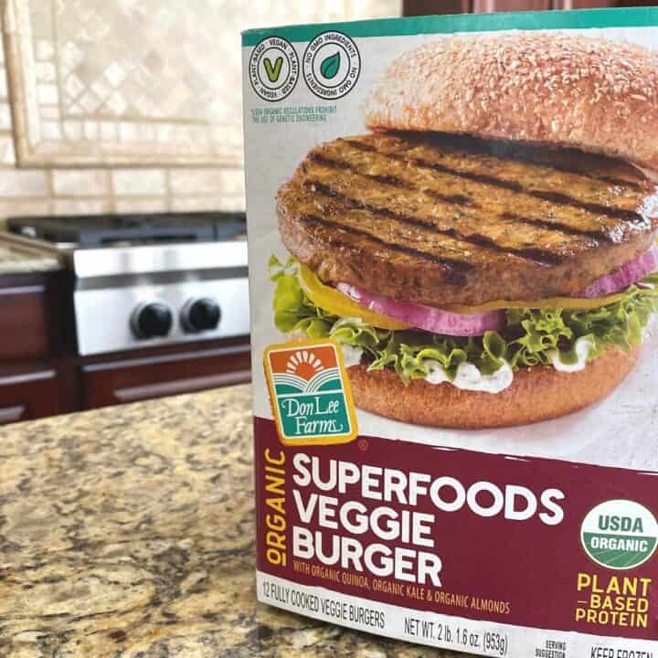 Box of organic veggie burgers sits atop a brown mottled granite counter