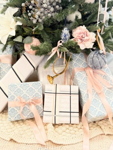 presents wrapped in blue white and pink paper under a tree