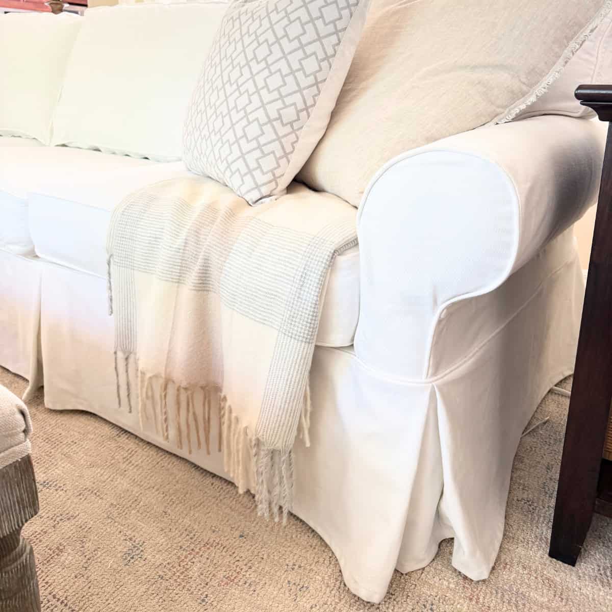 white slipcovered sofa pleated bottom